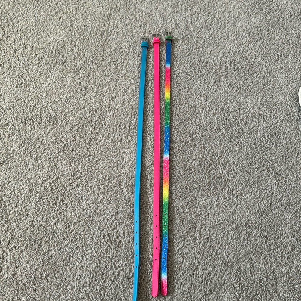 3 girls size belts. In the colors blue, pink and rainbow.